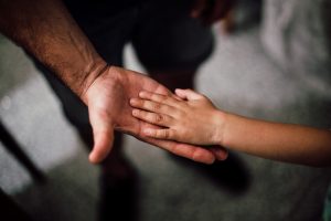 A father holding out his hand to his son's hand